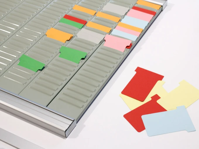 Weekly T-Card planner - Graphic design with rectangular colored boxes on a gray background.
