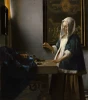 Reproduction of Woman Holding a Balance by Johannes Vermeer - Styled in a room with light walls and a table of items.