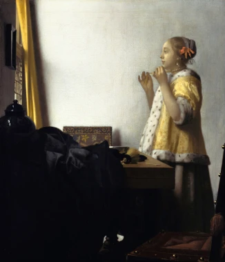 Reproduction of Young Woman with a Pearl Necklace by Johannes Vermeer, styled in a bright room with neutral walls.
