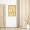 Wall sticker with the phrase "Finish what you started" - Room decor. Light-colored wall, wooden floor.