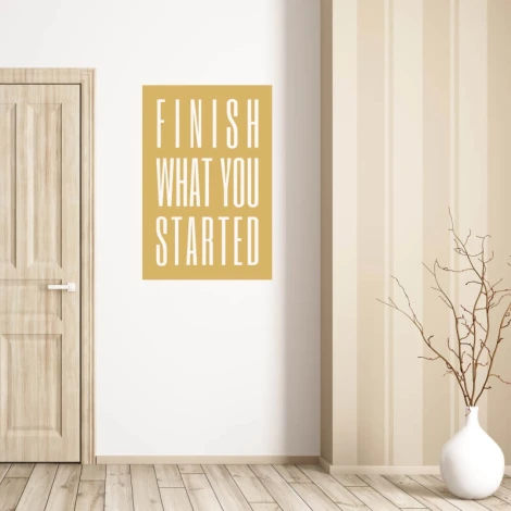 Wall sticker with the phrase "Finish what you started" - Room decor. Light-colored wall, wooden floor.