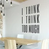 Wall sticker with the phrase "I think I think too much" - Dining room decor with light-colored walls and a wooden table.