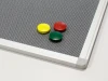 Pinmag magnetic board - Graphic design. Gray textile surface with three colored magnets.