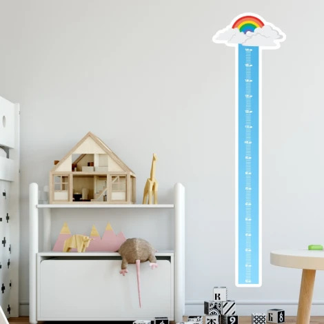 Rainbow growth chart sticker for kids\' room. Light-colored wall with furniture in soft shades.