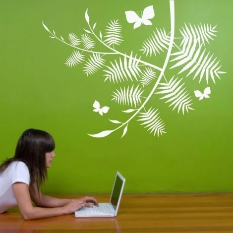 Elegant white butterfly branch against a vibrant green wall, perfect for modern decor.