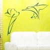 Hummingbird in flight with a flower on an energetic yellow wall in a modern living room, adding a touch of lightness.