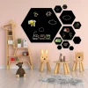 Hexagonal chalkboard in a child\'s room. Light-colored walls and natural furniture.