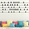 Bird wall template 2484 - Living room arrangement with light-colored walls and cushions in various patterns and colors.