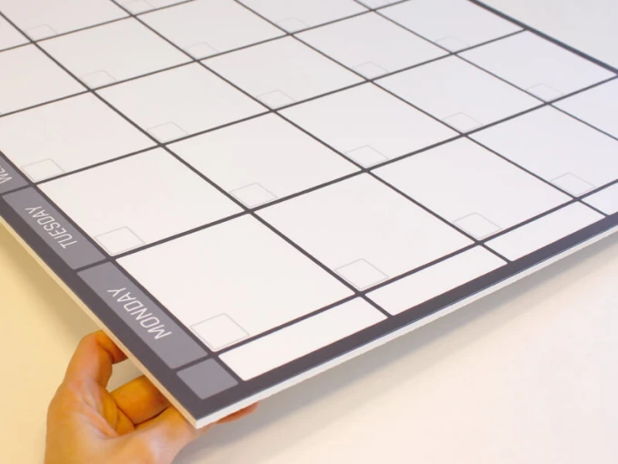 Weekly planner dry-erase board in English, featuring a simple grid with rectangular boxes for each day.