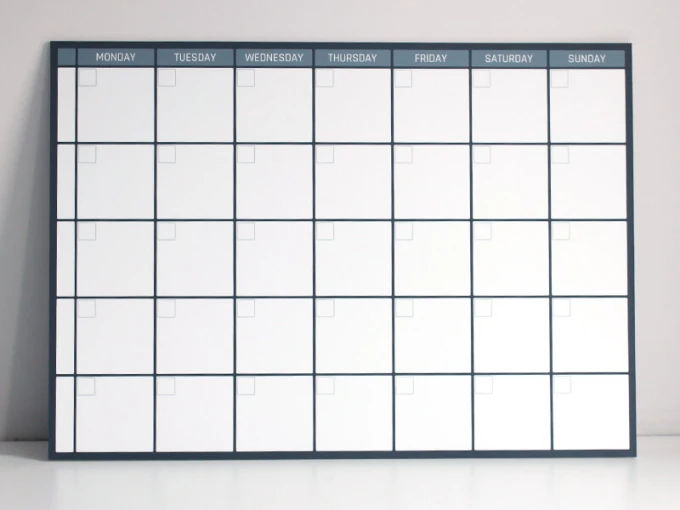 Weekly planner whiteboard in English, featuring a simple grid with rectangles for each day of the week.