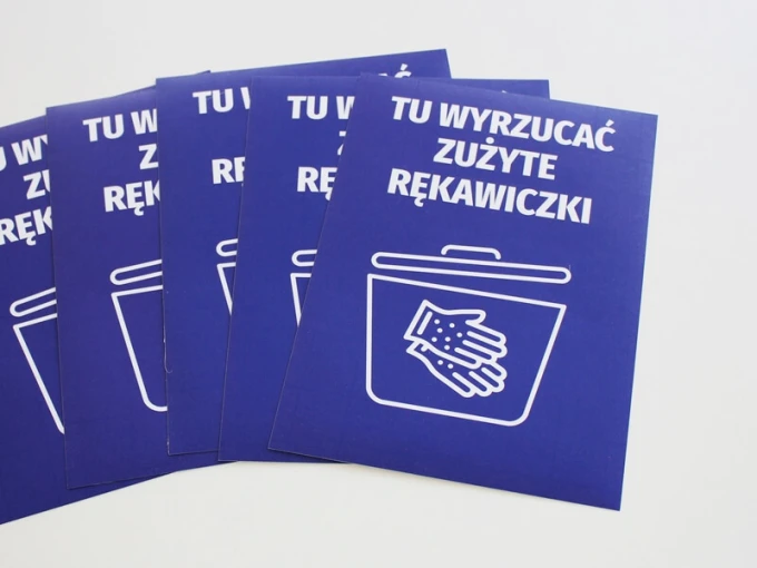 Sticker: Dispose of used gloves here - Graphic design. A white outline of a bin and hand on a blue background.
