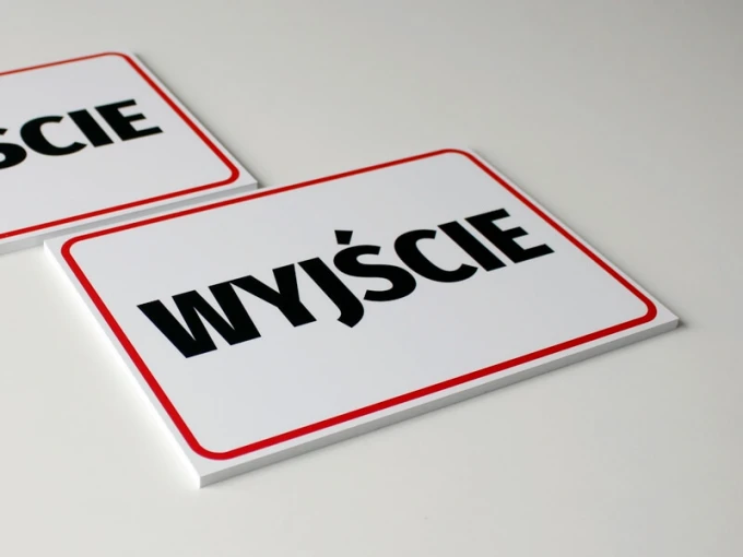 Exit sign T047 - Rectangular design with a white background, large black text, and a red border.