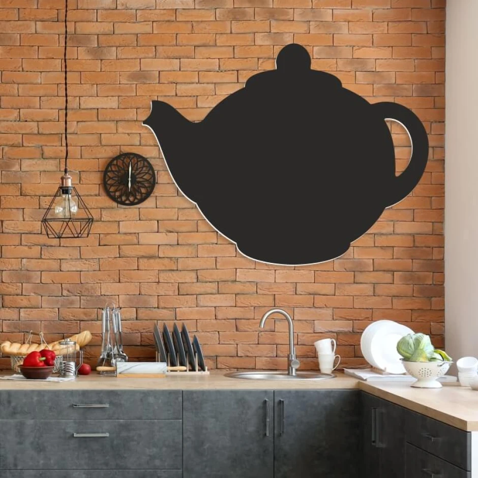Chalkboard magnetic board for kitchen, featuring a teapot design. Brick-colored walls and gray furniture.