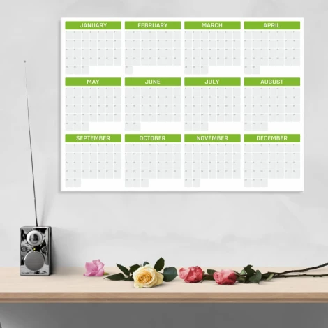 Universal dry-erase annual calendar in English, ideal for office decor. Bright walls and a table setting.