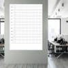 Universal dry-erase calendar in English, ideal for office setup with light-colored walls and modern furniture.