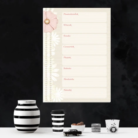 Weekly planner dry-erase board with floral design. Light background featuring flowers and writing lines.