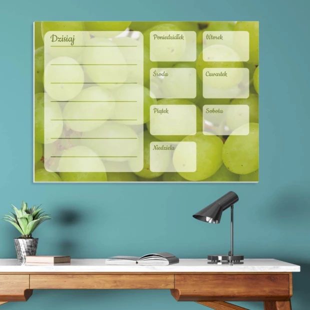 Weekly planner whiteboard with grape design - Office setup featuring blue walls and a wooden table with a lamp.