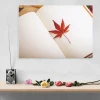 Magnetic whiteboard with a graphic design featuring a red maple leaf on a white background.