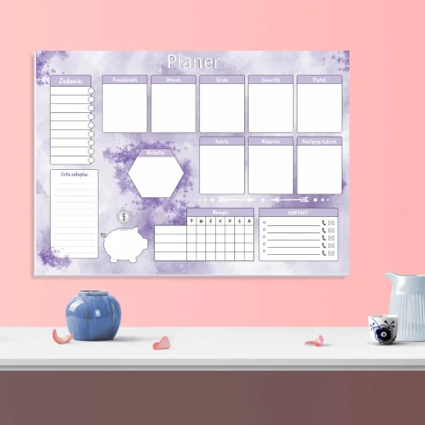 Magnetic dry-erase weekly planner board for kitchen decor. Pastel pink walls and a white wooden table.