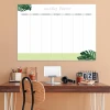 Magnetic dry-erase weekly planner for office use. Brown walls and wooden furniture.
