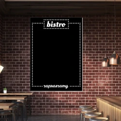 Chalkboard with bistro print for restaurant decor. Dark brick walls, wooden furniture, and lighting.