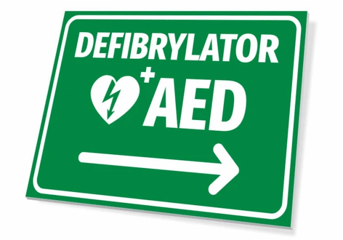 AED Defibrillator T560 Sign - Graphic design. Green background, white text, heart symbol with lightning, right arrow.