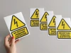Electrical device do not touch sticker - Graphic design. Yellow triangle with lightning and black text.