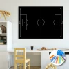 Chalkboard with football field print, styled in a bright room with light walls and natural-colored furniture.
