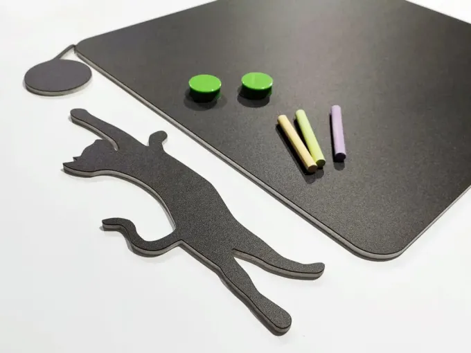 Chalkboard magnetic board for kids featuring a jumping cat design, along with crayons and magnets.