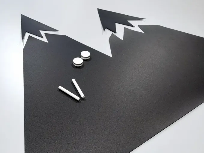 Chalkboard magnetic board for kids featuring a mountain design with two pointed shapes in color.