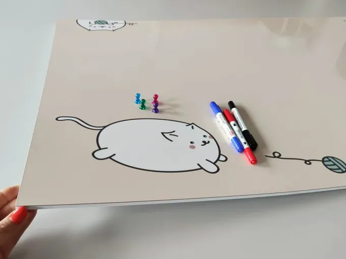 Dry-erase magnetic board for kids featuring a cat design on a light background.
