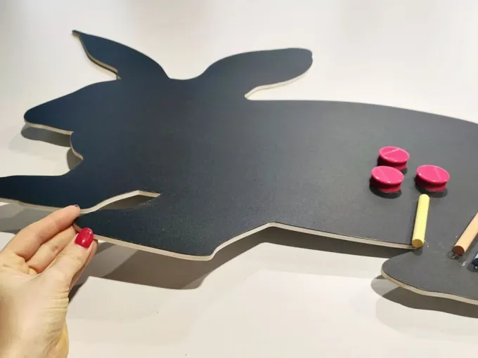 Chalkboard magnetic board for kids, rabbit design with cut-out ears and crayons nearby.
