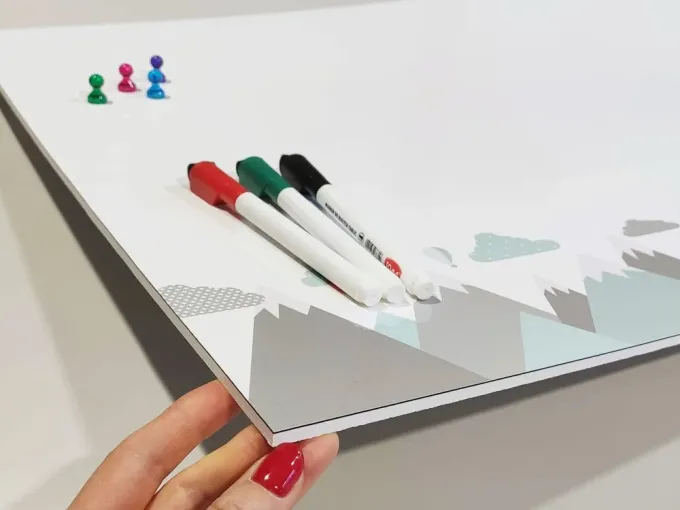 Magnetic dry-erase board for kids featuring animals and mountains, with a gray border at the bottom.