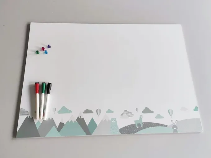 Magnetic dry-erase board for kids featuring animals and mountains, with clouds visible at the bottom.
