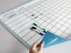 Magnetic dry-erase board with annual Gantt chart divided by months, featuring a simple grid design.