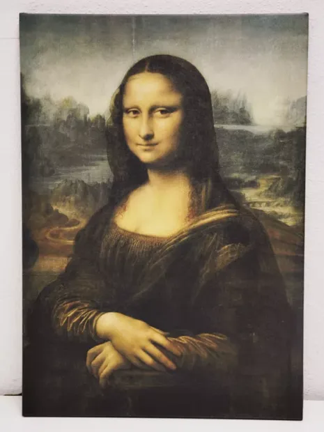 Reproduction of The Mona Lisa by Leonardo da Vinci. Woman with a smile against a landscape background.