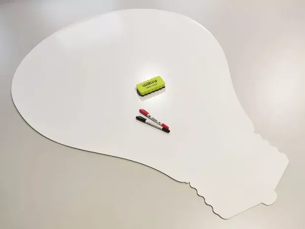 Dry-erase magnetic board in the shape of a light bulb with clear contours.