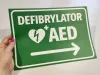 AED Defibrillator Sticker N560 - Graphic design. Green background with white text, heart symbol, and arrow.