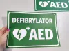 AED Defibrillator Sticker N562 - Graphic design. Green background with white text and heart symbol with lightning bolt.