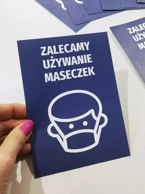 Sticker: We recommend wearing masks - Graphic design. White figure with a mask on a blue background.