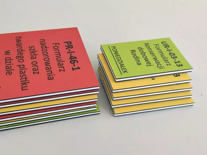 Double-sided printed magnet with a 2mm PVC core, featuring a graphic design in yellow, green, and red.