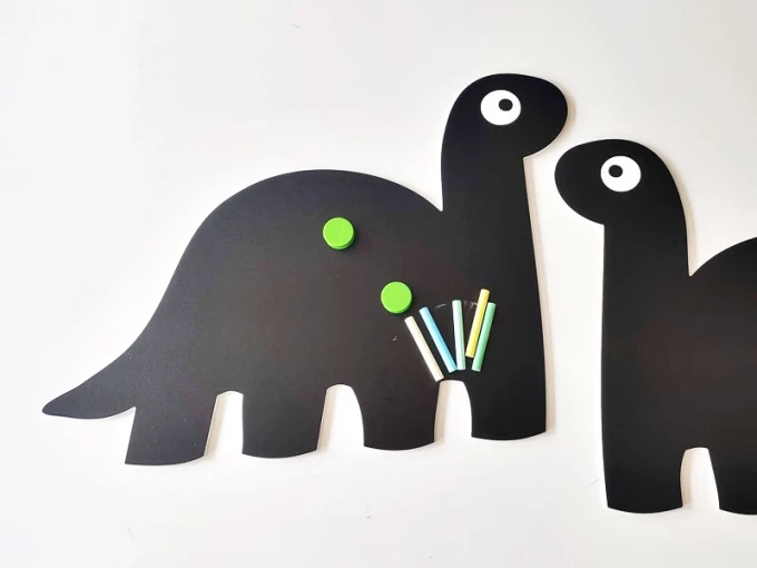 Chalkboard magnetic board for kids featuring dinosaur design with two rectangular dinosaurs and large eyes.