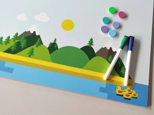 Dry-erase magnetic board for kids, featuring a paradise island design with green hills and mountains.