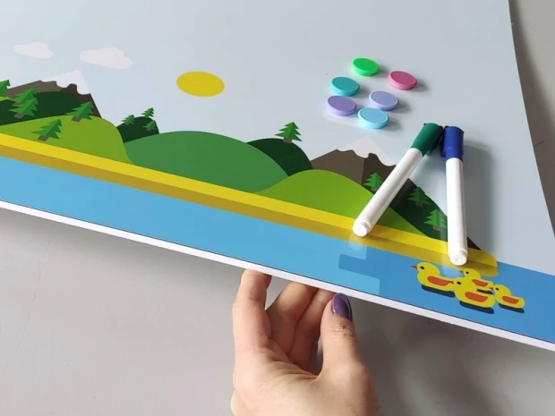 Dry-erase magnetic board for kids, featuring a paradise island design with sun, mountains, trees, and a blue sky.