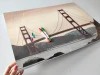 Dry-erase magnetic board featuring the Golden Gate Bridge with red towers against a backdrop of water and mountains.