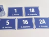 Address plaque with street and house number - Graphic design. Simple rectangular shapes with white text on a blue background.