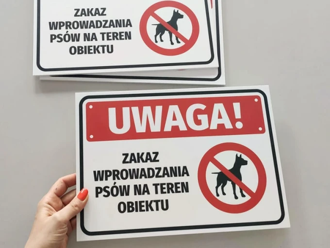 Warning sign: No dogs allowed on the premises - Graphic design. Rectangular sign with red circles.