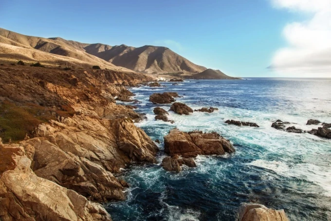 Rocky seaside wallpaper FP 6446 - Graphic design featuring visible rocks, waves, and mountains in the background.