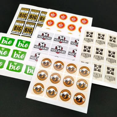 Custom adhesive label with graphic design. Features various shapes and colors, including text and symbols.