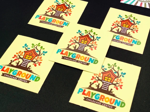 Custom printed adhesive stickers - Square shape with a colorful house and tree design.